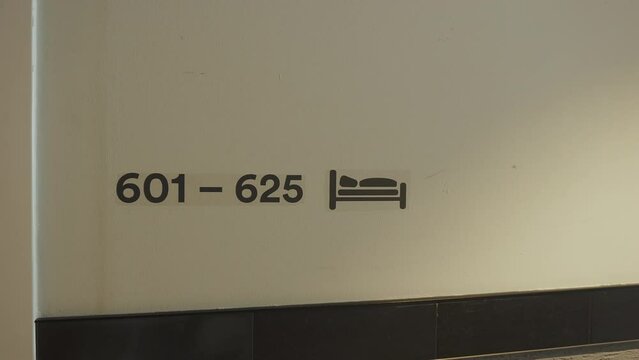 Indication of hotel room numbers on 6th floor in high-rise hotel on white wall. Information and assistance with orientation of tourists in hotel complex. Rest room numbers are from 601 to 625.