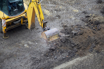  the excavator bucket begins work, yellow excavator on a land construction site