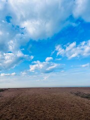 dune at the sea shore, blue sky with white clouds, idyllic seascape