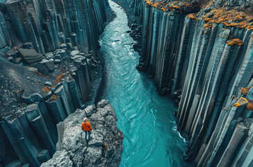  Iceland's mysterious basalt columns with woman standing on one in the middle looking down into deep blue river below