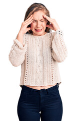 Young beautiful blonde woman wearing casual sweater with hand on head, headache because stress. suffering migraine.