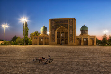 A bicycle lies on the square in front of the mosque at night. Tashkent. Uzbekistan - 775228460