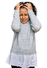 Young little girl with afro hair wearing casual clothes suffering from headache desperate and stressed because pain and migraine. hands on head.