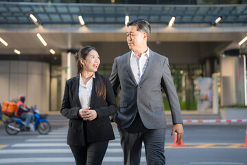 Business colleagues walking across street - 775232400