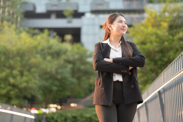 Professional young woman in a suit smiles confidently outside a modern office building - 775232416