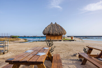 View of seaside restaurant featuring wooden tables outdoors with backdrop of Caribbean Sea on...