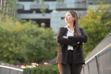 Professional young woman in a suit smiles confidently outside a modern office building