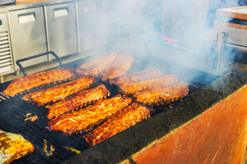 Close-up view of grilling pork ribs outdoors at restaurant. Curacao. 