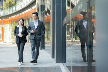 Business colleagues walking together in modern business district - 775232890