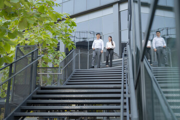 Business colleagues walking downstairs outdoors - 775233052