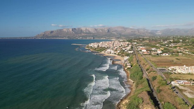 Aerial shot of the sea in Balestrate, Sicily, with waves crashing on the rocky coastline.