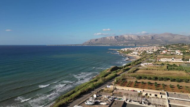 Aerial shot of the sea in Balestrate, Sicily, with waves crashing on the rocky coastline.