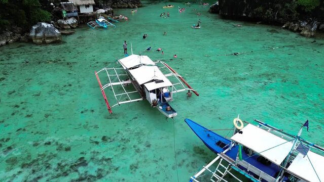 Drone view of banca boats on crystal clear water of the ocean in Palawan, Philippines