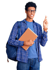 Young african american man wearing student backpack holding book gesturing finger crossed smiling with hope and eyes closed. luck and superstitious concept.