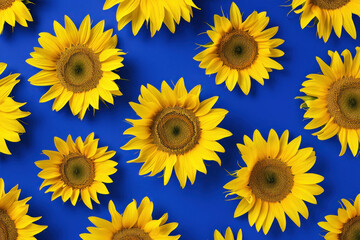 Vibrant pattern of many yellow sunflowers arranged on a blue background with a striking contrast
