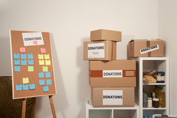 donations of food and medicine. Cardboard Boxes of donations and shelves with products at a small distribution Volunteer house with a cork board for planing