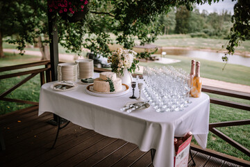 Valmiera, Latvia - Augist 13, 2023 - A wedding cake table set up outdoors with a two-tier cake,...