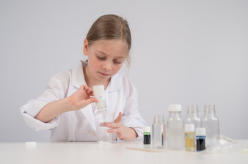 Caucasian girl doing chemical experiments on a white background. 