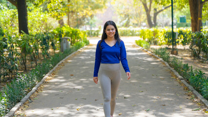 Young woman walking in the park, also known as jogging or morning walk, outdoor fitness concept