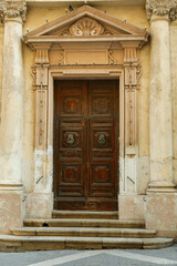Fototapeta na wymiar Old wooden door with decorative elements in city