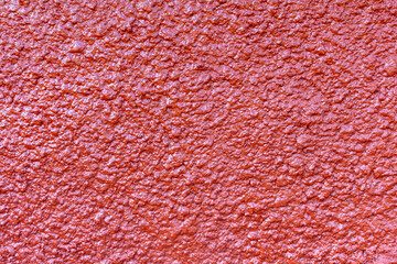 Close-up view of old textured salmon (or terra cotta) coloured rough painted wall surface. Copy...