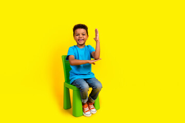 Full size photo of diligent schoolboy wear blue t-shirt sit on chair raising arm up answer question...