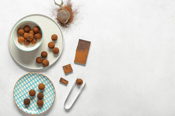Plates with tasty chocolate truffles on white background