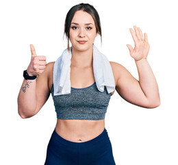 Young hispanic girl wearing sportswear and towel showing and pointing up with fingers number six while smiling confident and happy.