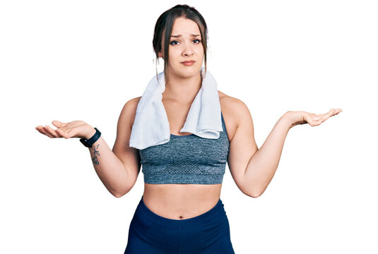 Young hispanic girl wearing sportswear and towel clueless and confused with open arms, no idea concept.