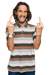 Young hispanic man wearing casual clothes showing middle finger doing fuck you bad expression,...