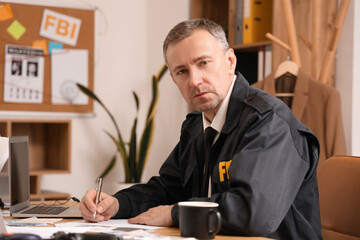 Mature FBI agent working at table in office