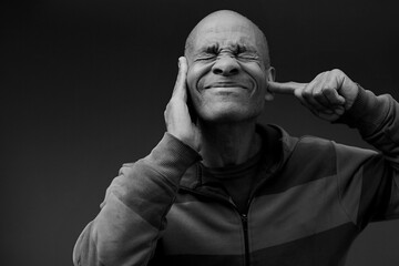 deaf man suffering from deafness and hearing loss on gray background with people stock image stock photo	