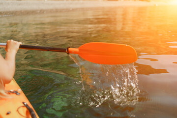 Kayak paddle sea vacation. Person paddles with orange paddle oar on kayak in sea. Leisure active...