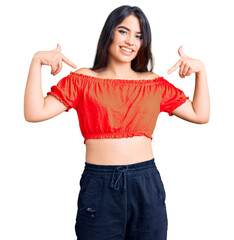 Brunette teenager girl wearing casual clothes looking confident with smile on face, pointing oneself with fingers proud and happy.