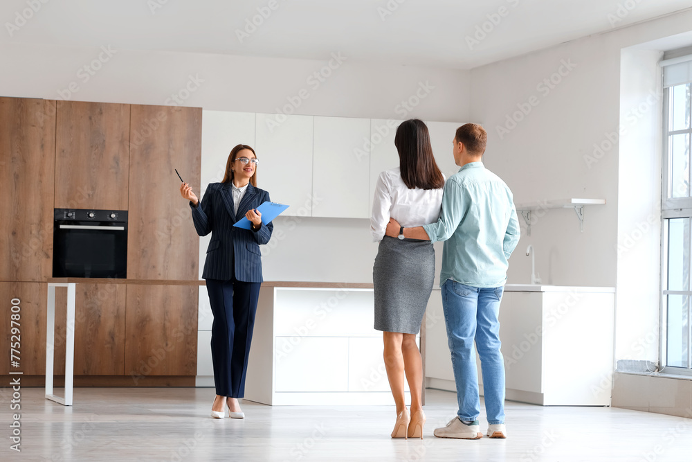 Sticker female real estate agent with clipboard showing young couple kitchen in new house