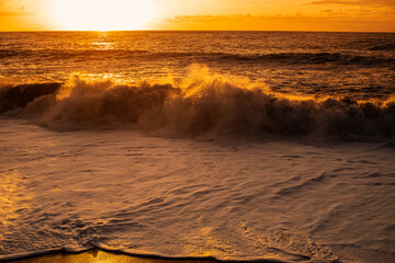 Seascape at sunset. Orange background of sky and setting sun over the sea on a summer evening