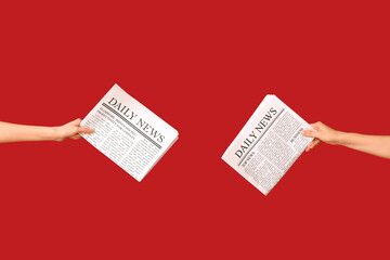 Female hands with newspapers on red background - obrazy, fototapety, plakaty