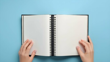 Woman with open photo album at light blue background, top view. Space for text