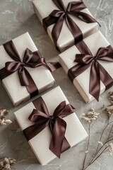 Three elegant gift boxes with brown ribbons and floral decorations. Perfect for gift-giving occasions