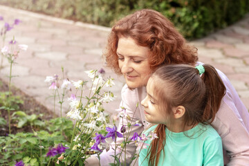 Mom and daughter walk in the park and look at flowers. Allergy
