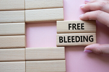 Free bleeding symbol. Concept words Free bleeding on wooden blocks. Beautiful pink background....