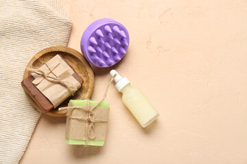 Hair scalp massager with shampoo bars and cosmetic oil on grunge beige background