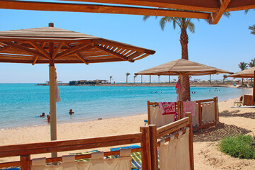 Seaside resort. Wooden umbrellas. tropical resort with palm trees sandy beach