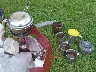 Boiling tea for travelers. Mugs with coffee in nature. Tourist dishes
