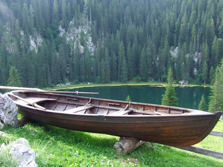 Rural boat standing near mountain forest and lake. Mountain panorama