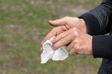 Man wiping his hands with a damp cloth after work.Dirty male hands.