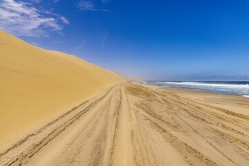 Fototapeta na wymiar Picture of the beach of the dunes of Sandwich Harbor in namibia tgas over at low tide
