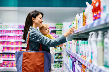 Small girl and her mother shopping in supermarket.