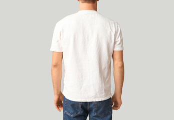 Man in stylish t-shirt  on light background, back view