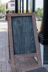 Blank black chalk board on street near cafe or shop